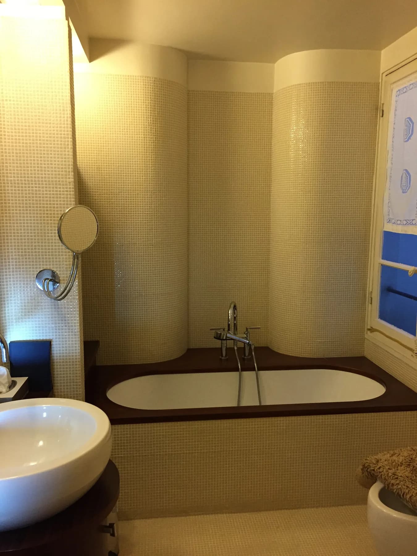 Baignoire encastrée entourée de mosaïque beige
